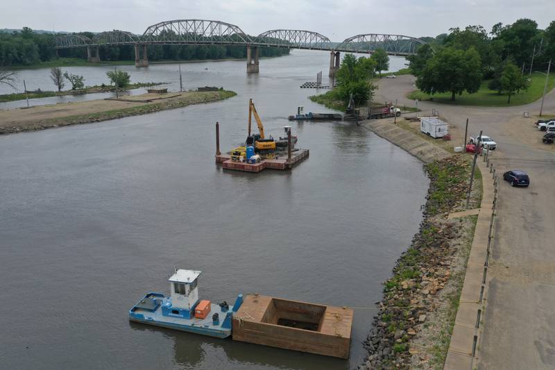 Crews with Superior Sea Walls and Docks, dredge the Henry Marina on Monday, June 9, 2025 in Henry.  The operation involves using an excavator on a flat barge while removing silt from the water and placing it into a smaller barge that is pushed to the shoreline by a small tug boat. 
An additional excavator will move the silt onto a tandem truck and then moved off-site. The trucks are dumping the material on a city farm located north of town. 
Once completed the Henry Yacht Club will begin installation of replacement docks.