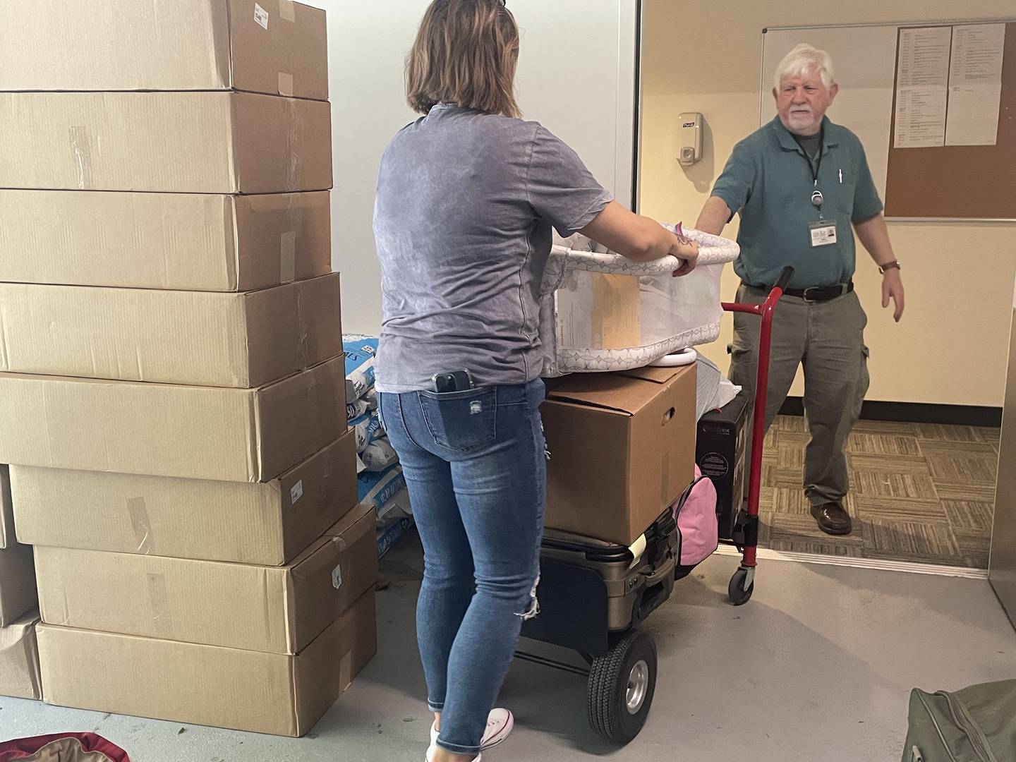 Organizers behind the donation and collection event held May 31, 2024, in support of the dozens of residents impacted by the May 29, 2024, Husky Ridge Apartment fire load a hand truck with donations at the DeKalb Public Library, 309 Oak St.