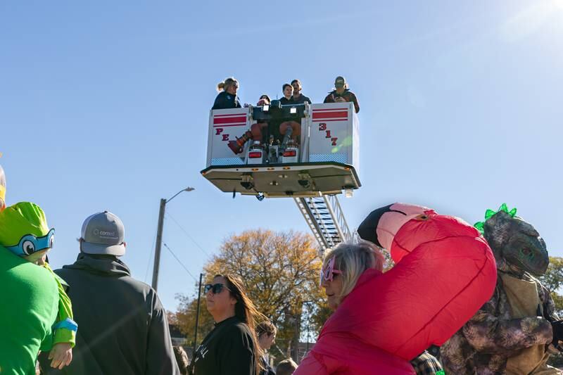 People ride in Peru fire department’s lifted basket overseeing Peru at the annual trick or treat at Washington park on Saturday, October 26, 2024 in Peru.