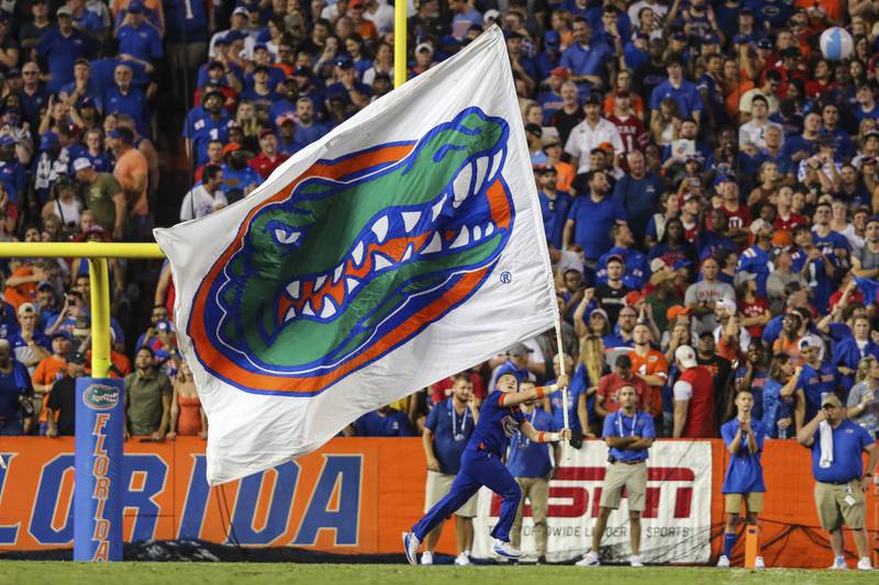 Member of the Florida cheer squad with a Gator-logoed flag celebrates a touchdown during an NCAA football game between Florida and Utah on Saturday, Sept. 3, 2022 in Gainesville, Fla. Florida defeated Utah 29-26. (AP Photo/Gary McCullough)