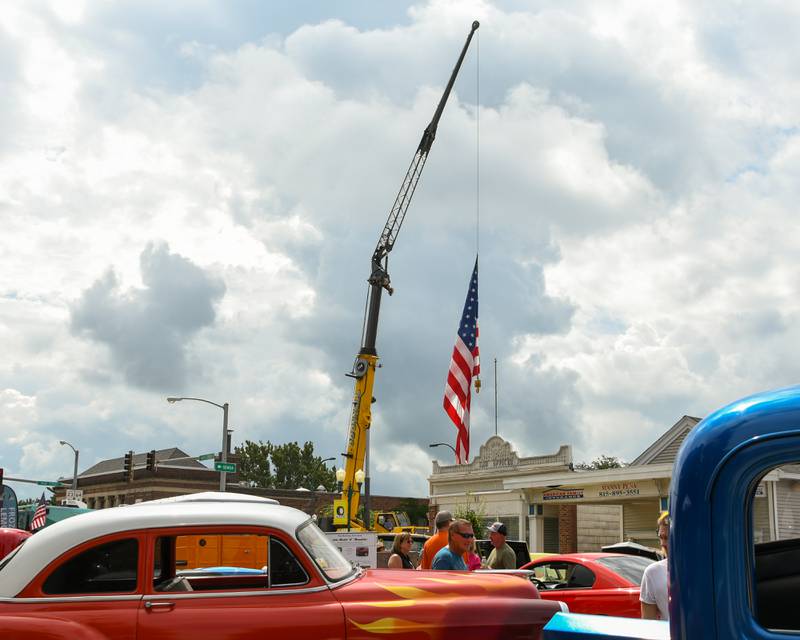 O’Donnell crane service raises an American flag over the street during the Turning back time car show on Sunday July 27, 2025, held in downtown Sycamore.