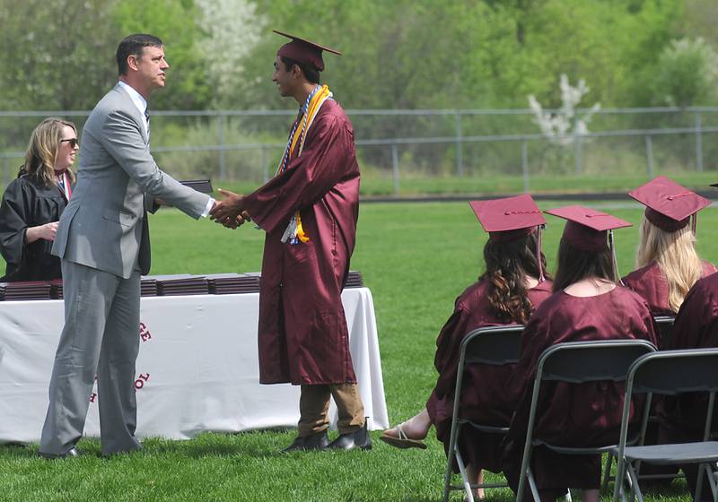 Community High School District 155 school board President Jason Blake hands Sayak Dubey his diploma Saturday, May 14, 2022, during the graduation ceremony at Prairie Ridge High School.