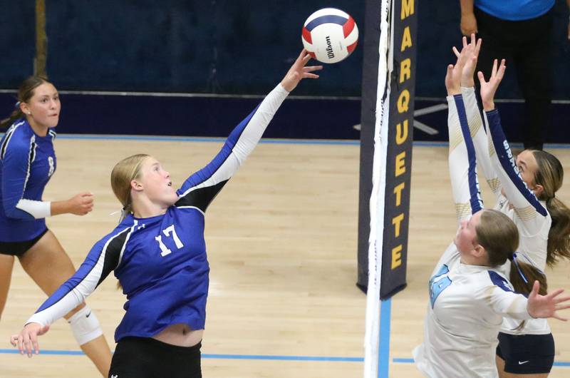 Newark's Zoey Carlson sends a kill past Marquette's Kelsey Cuchra and Kaitlyn Davis on Wednesday, Aug. 27, 2025 in Bader Gymnasium.