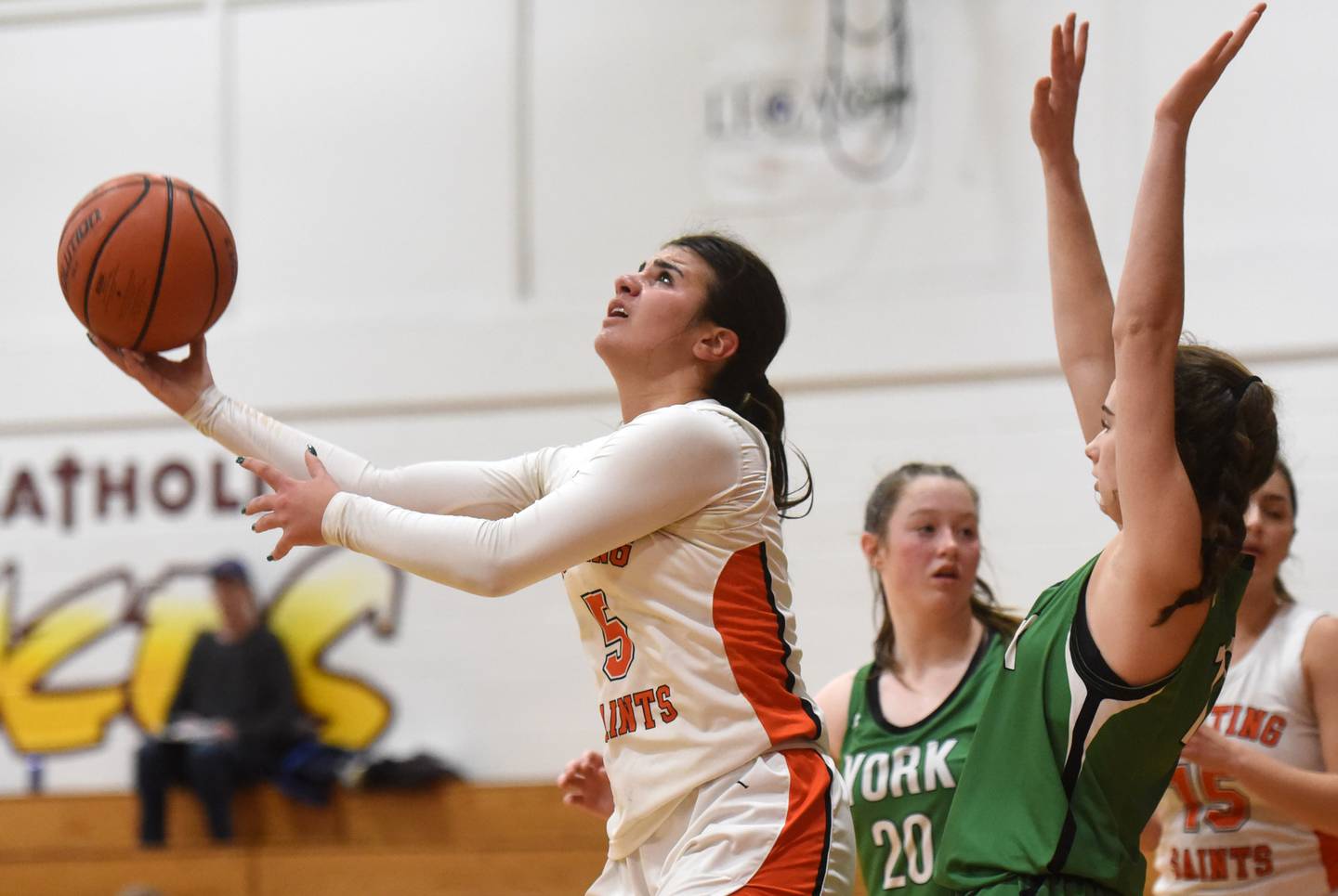 St. Charles East’s Lexi DiOrio, left, attempt an underhanded shot with her back to the basket as well as York defender Ellie Kehoe, but a whistle was blown and York took possession of the ball during the semifinal of the Montini girls basketball tournament Thursday December 28, 2023 in Lombard.