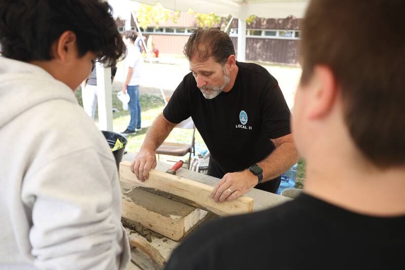 Students get a masonry demonstration at one of the trade skills tents at the Grundy Area Vocational Center 8th grade Career Fair at Morris High School on Tuesday, Oct. 29, 2024 in Morris