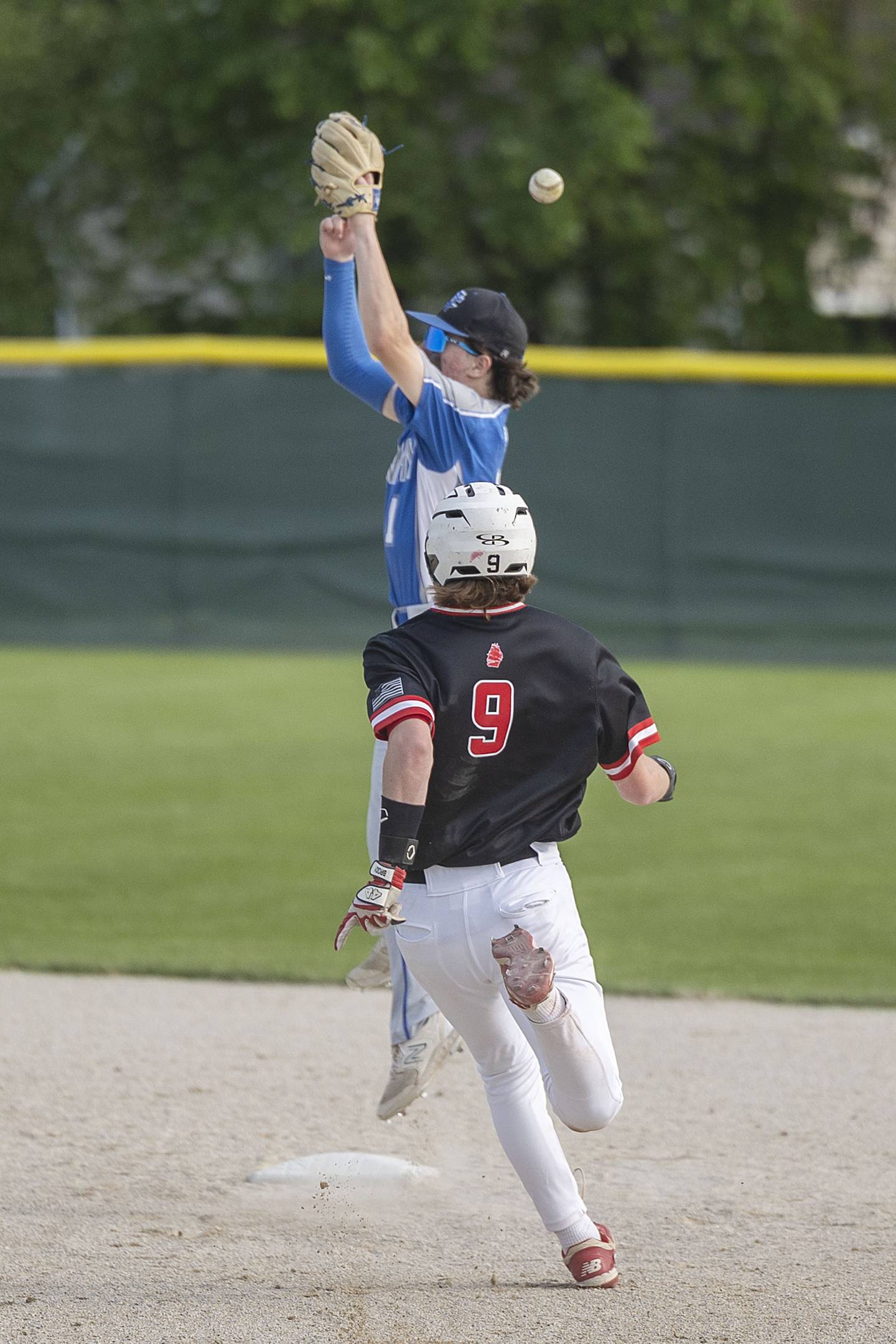 Newman’s Garret Matznick leaps for a high throw as Amboy’s Brody Christofferson heads for second Thursday, May 18, 2023.