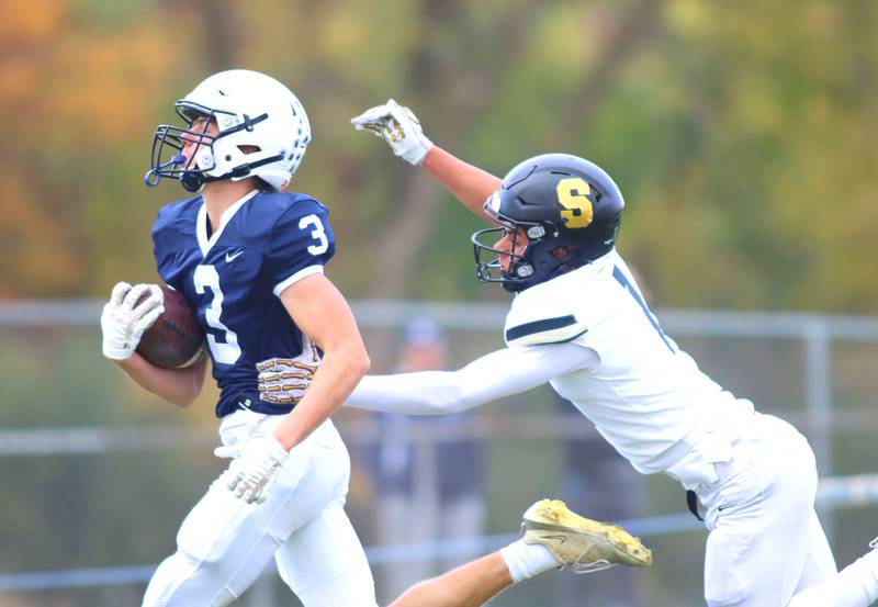 Cary-Grove’s Ty Tenopir, left, eludes Sycamore’s Josiah Mitchell at the end zone on a Trojan touchdown in IHSA football Class 5A first-round playoff action at Al Bohrer Field on the campus of Cary-Grove High School in Cary on Saturday, November 1, 2025.