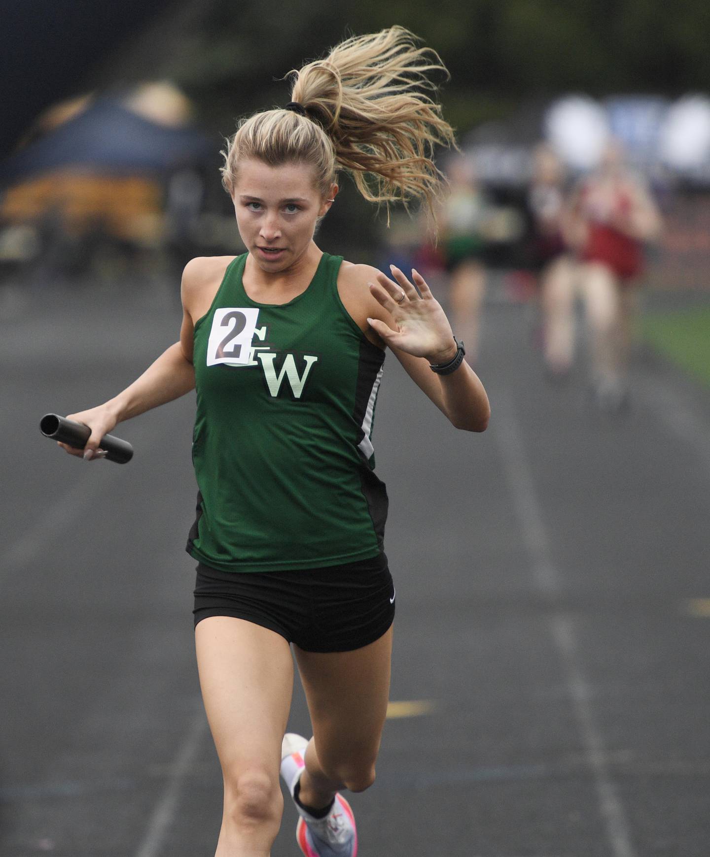Glenbard West’s Audrey Allman finishes the anchor leg of the of the 4x200-meter relay at the Wheaton Warrenville South girls track invitational in Wheaton on Friday, April 29, 2022.