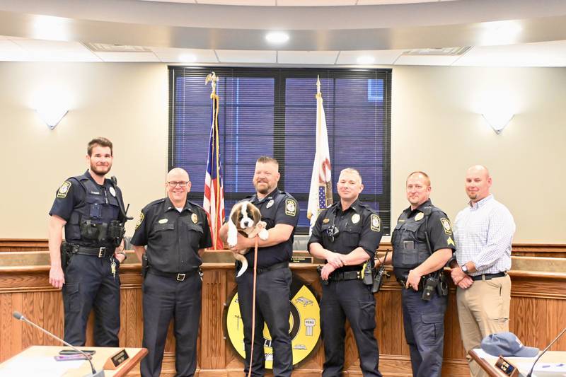 Peru Police Officers stand with newest member Haven during Peru's City Council meeting on Monday, May 6, 2024.