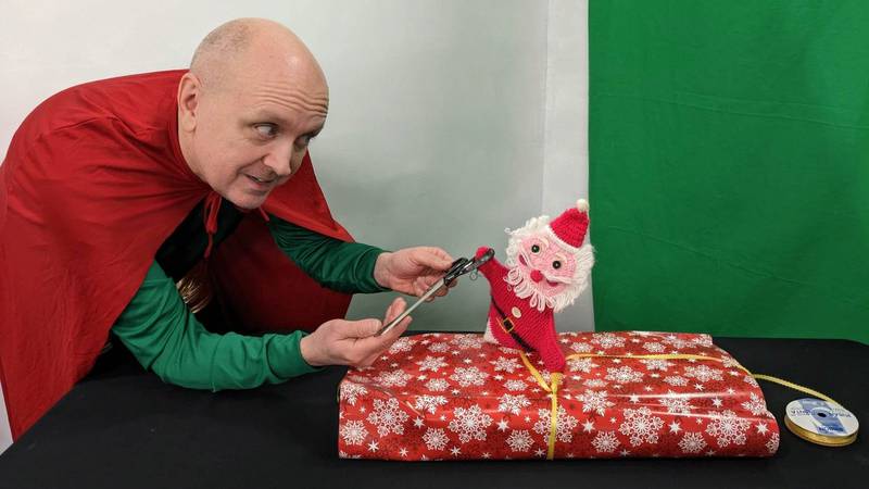 Wrap Man (Danny Glenn from left) teaches Roy the finer points of wrapping a present in "Seasonal Gifts" from WT Productions.