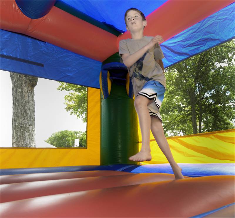 Ryker Thompson gets up and down in one of the many bounce houses Saturday during Spring Valley’s Summerfest.