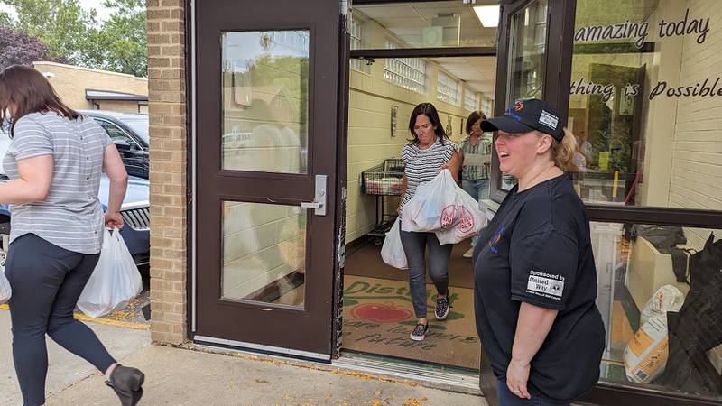 Lana Howe, president and founder of Bags of Hope (right) greets school social workers as Bags of Hope board members Allison Suchinski (center, front) and Nancy Crouch (center, back) carry bags of food to the cars on Wednesday, October 4, 2023, at Plainfield Academy. Bags of Hope is a Plainfield-based nonprofit that feeds hundreds of Will County students each weekend through a donation-funded backpack program.