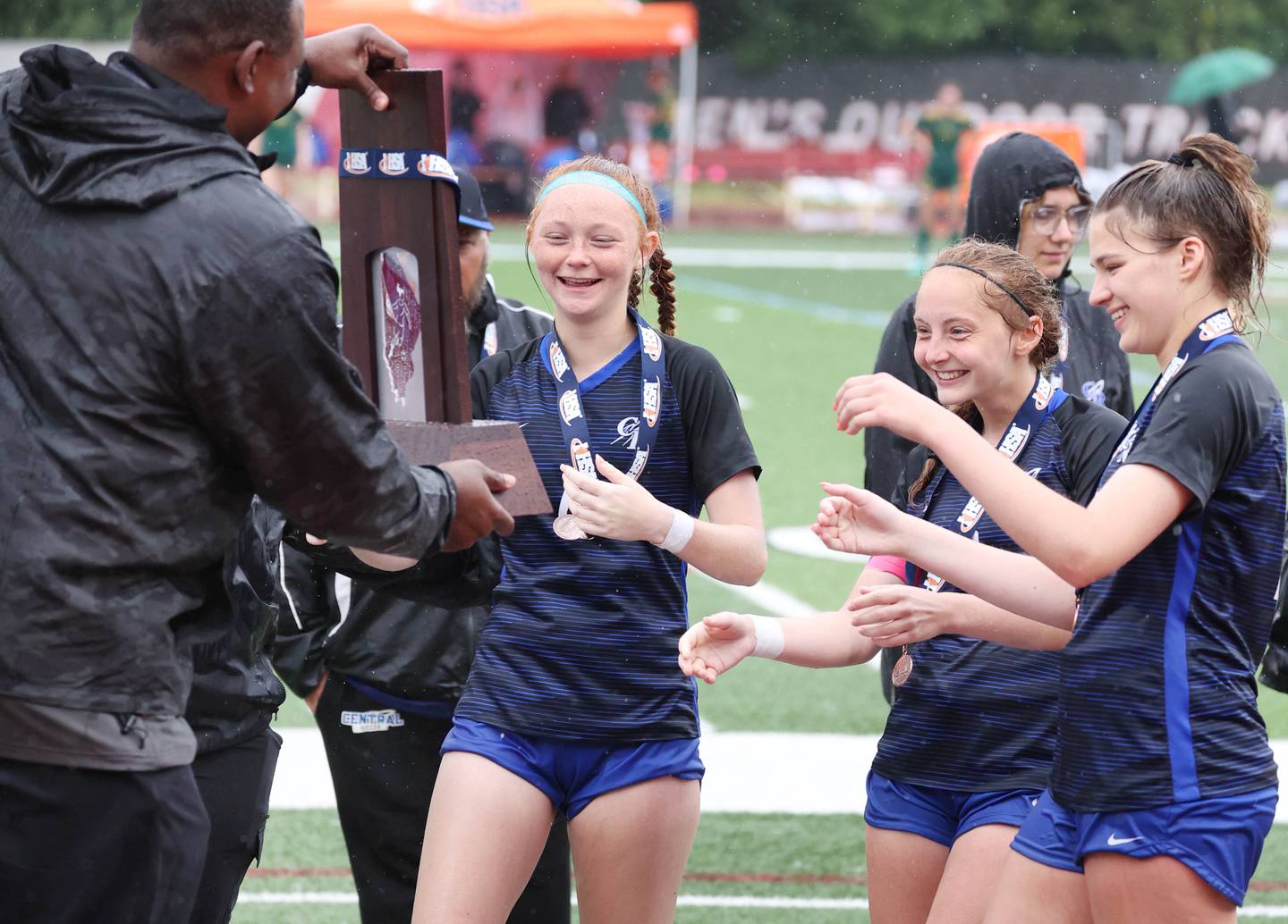 Burlington Central's team captains accept the state fourth place trophy Saturday, June 1, 2024, after their consolation match loss to Peoria Notre Dame at the IHSA Class 2A state soccer finals at North Central College in Naperville.