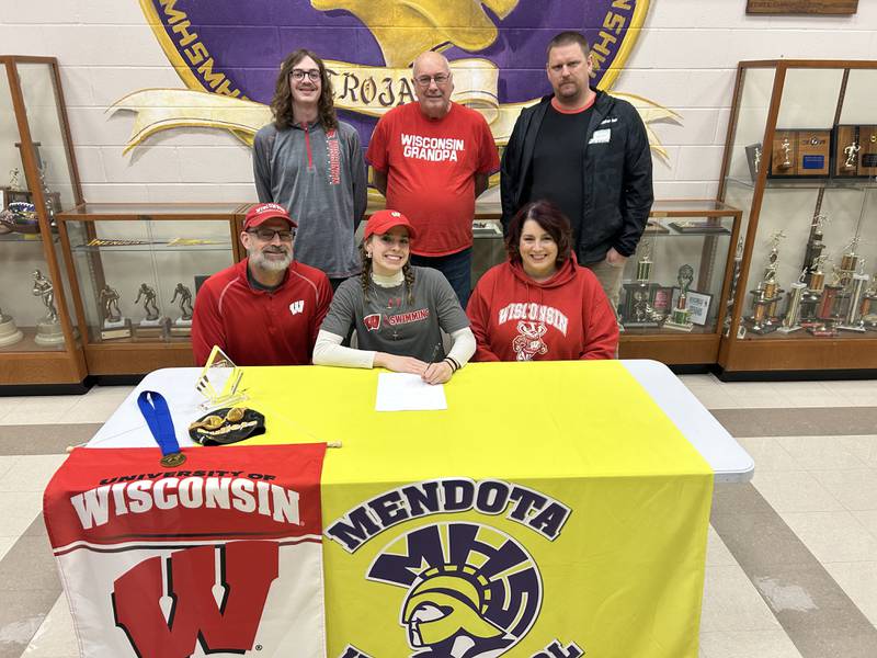 Mendota senior Bridget McGann (seated, center) signed a National Letter of Intent to swim at the University of Wisconsin. She was joined by her parents (seated) Patrick and Kimberly McGann and (standing from left) her brother, Patrick McGann, grandpa Mike Hall and coach Todd Capen.
