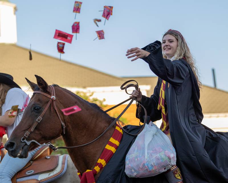 Parader atop of horse tosses candy to children at the annual Princeton Halloween Parade on Saturday, Oct. 4, 2025 on Main Street in Princeton.