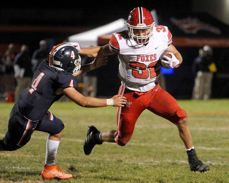 Yorkville running back Gio Zeman (32) stiff arms Oswego defender Colin Rowe (4)during a varsity football game at Oswego High School on Friday, Oct. 21, 2022.