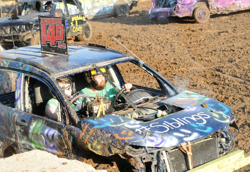Justin Shaner drives as his sister Jacqueline rides as a passenger in their demolition derby heat at the Ogle County Fair on Saturday, Aug. 5, 2023.