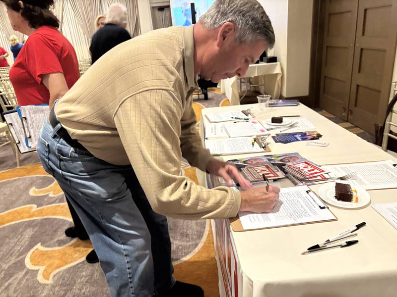 Rick Johnson of Crystal Lake signs a petition during a MCGOPAC event in memory of Charlie Kirk Oct. 14, 2025.