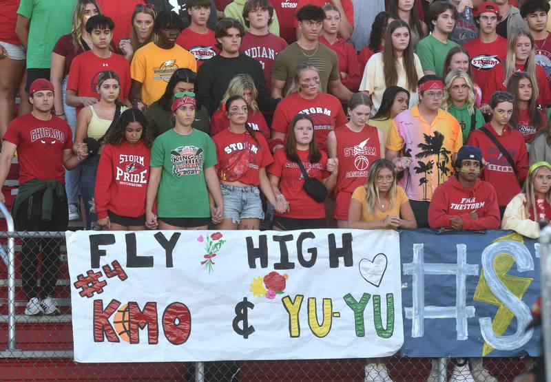 South Elgin students reflect during a moment of silence before the start of Friday's football gamme at Glenbard East in Lombard. A banner hangs in memory of the two South Elgin students killed in a crash Thursday near the school.