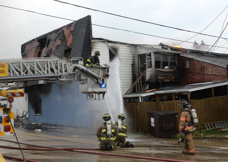 Firefighters from several departments responded to a structure fire at the corner of Main Street and Wesley Avenue in downtown Mt. Morris on Tuesday, April 16, 2024. The wooden structure housed two apartments and Sharky's Sports Bar. No injuries were reported. Firefighters battled high winds during the afternoon blaze.