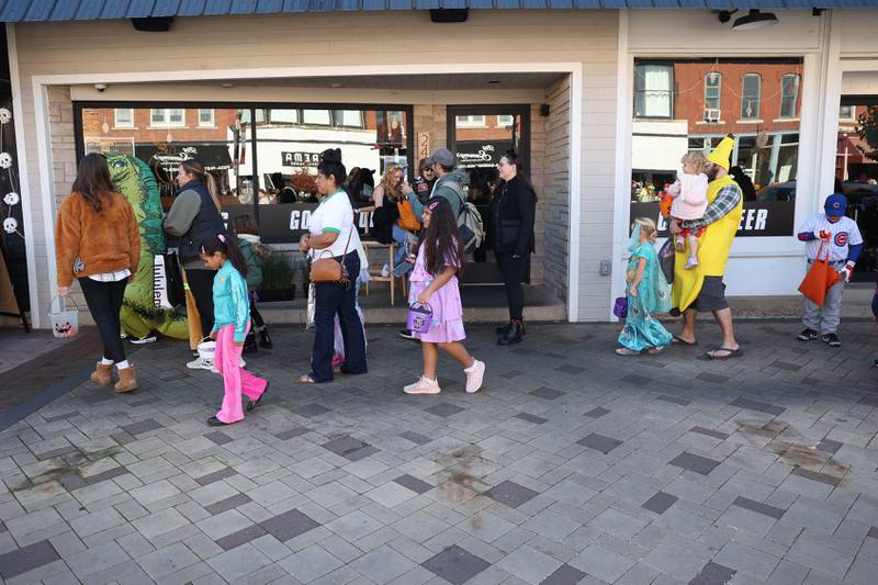 Families walk in line for candy and treats from the businesses along West Lockport Street at the annual Halloween Spooktacular in downtown Plainfield on Saturday, Oct. 28, 2023.