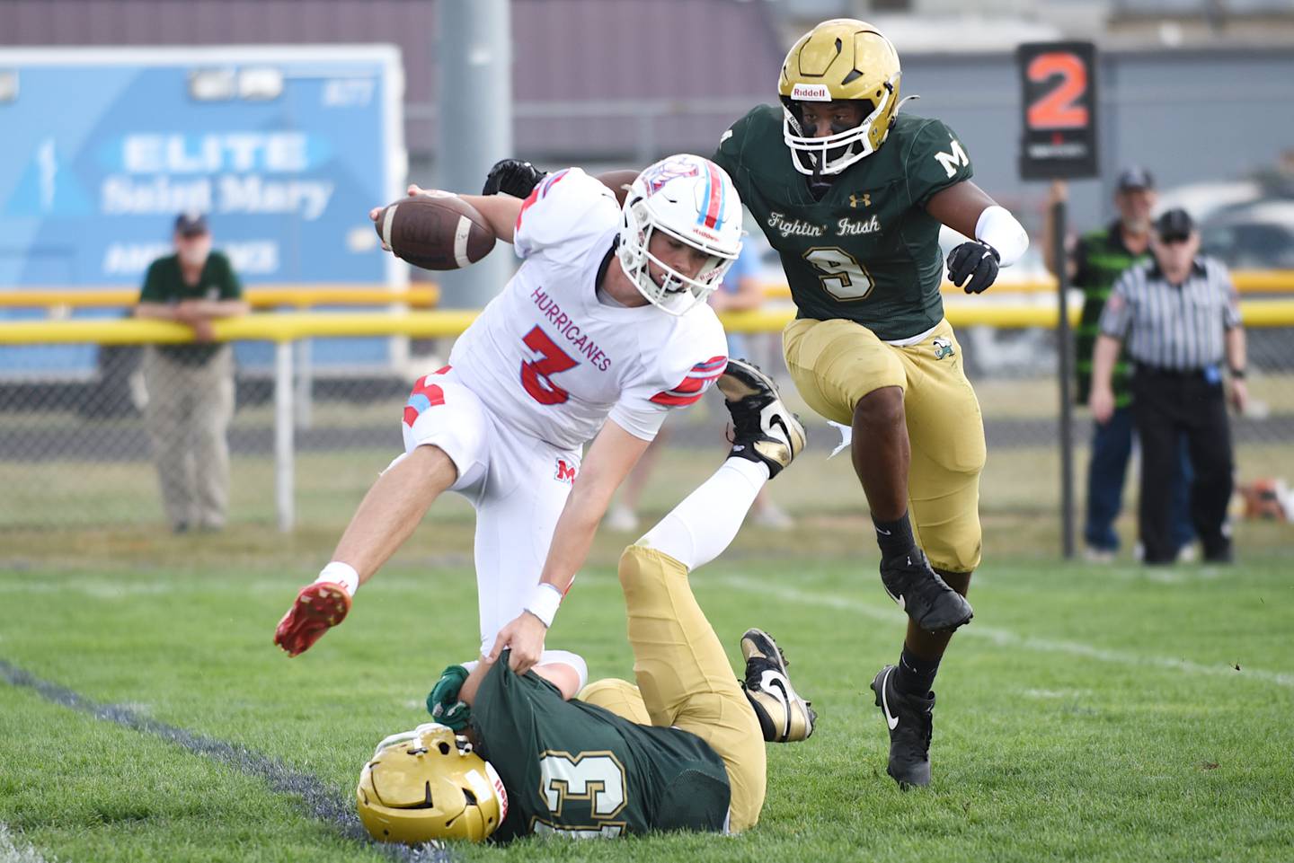 Marian Central's Colin Hernon, left, looks to avoid a tackle from Bishop McNamara's Tucker Inman as the Fightin' Irish's Julius May, right, approaches during a game at Bishop McNamara Saturday, Oct. 4, 2025.