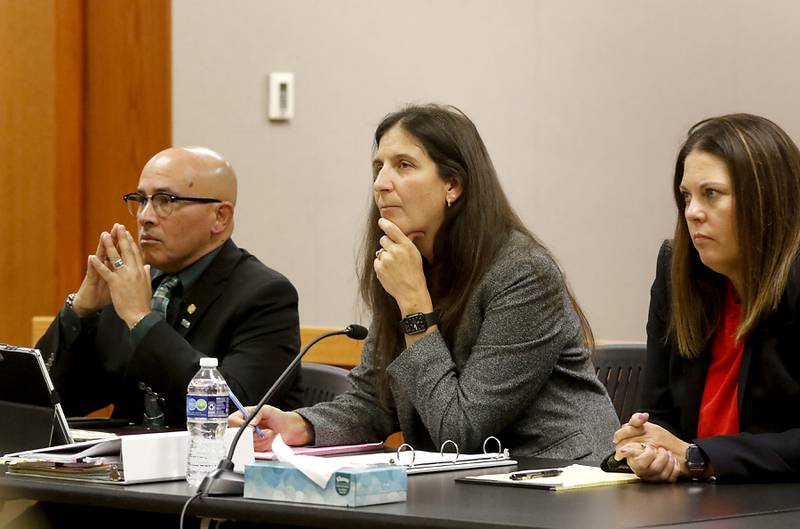 Carlos Acosta, defense attorney Rebecca Lee and defense attorney Jamie Wombacher listen as McHenry County State's Assistant Attorney Randi Freeze delivers the state’s closing argument the during the trial for the former Illinois Department of Children and Family Services employees Acosta and Andrew Polovin before Lake County Judge George Strickland on Friday, Oct. 13, 2023, at the McHenry County Courthouse. Acosta, 57, of Woodstock, and Polovin, 51, of Island Lake, each are charged with two counts of endangering the life of a child and health of a minor, Class 3 felonies, and one count of reckless conduct, a Class 4 felony, related to their handling of the AJ Freund case.