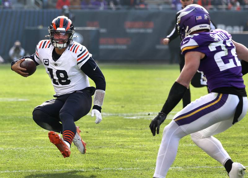 Chicago Bears quarterback Caleb Williams slides in front of Minnesota Vikings safety Harrison Smith after a good gain during their game Sunday, Nov. 24, 2024, at Soldier Field in Chicago.