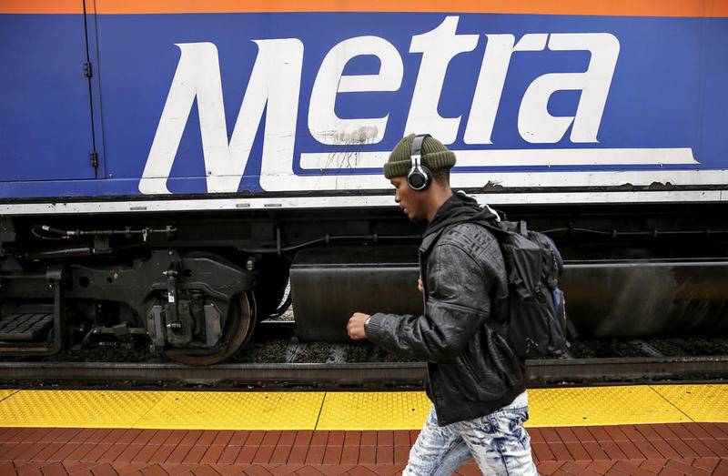 A passenger walks past a Metra engine Nov. 2 at the Joliet Rock Island District stop.