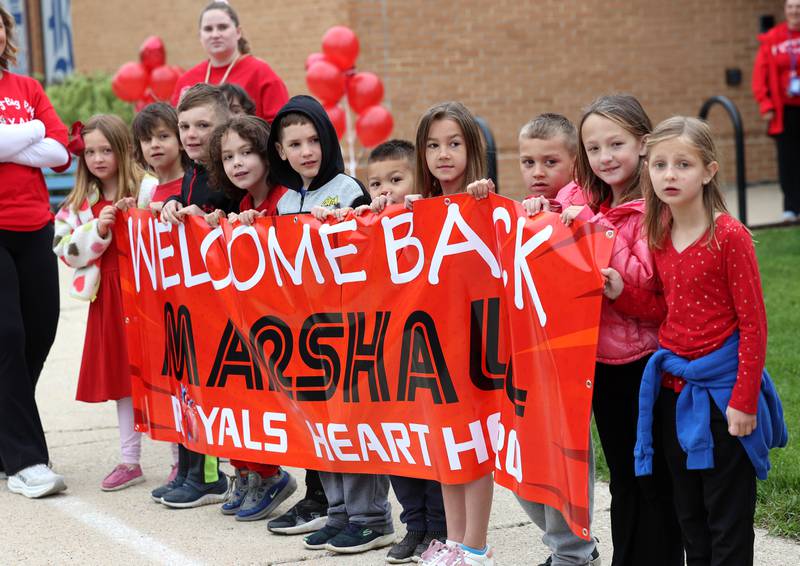 First grade classmates of Marshall Morong, 7, peer down Lincoln Avenue Monday, May 5, 2025, outside of Hinckley-Big Rock Elementary School, as they await his arrival for his first day back following months waiting for, and eventually receiving, heart transplant surgery at Lurie Children’s Hospital of Chicago. Morong arrived in style in a Tesla Cybertruck donated for use by Telsa of Naperville, along with an escort by Hinckley and Big Rock first responders.