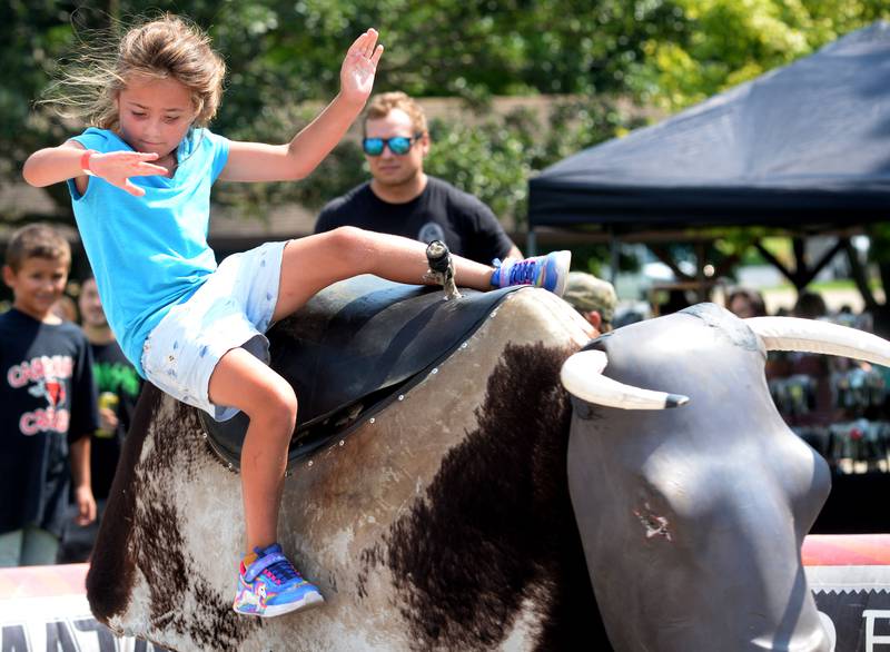 Brookelynn Zettle, 8, of Forreston, falls off the mechanical bull ride at Sauerkraut Days in Forreston on Saturday, Aug. 2, 2025.