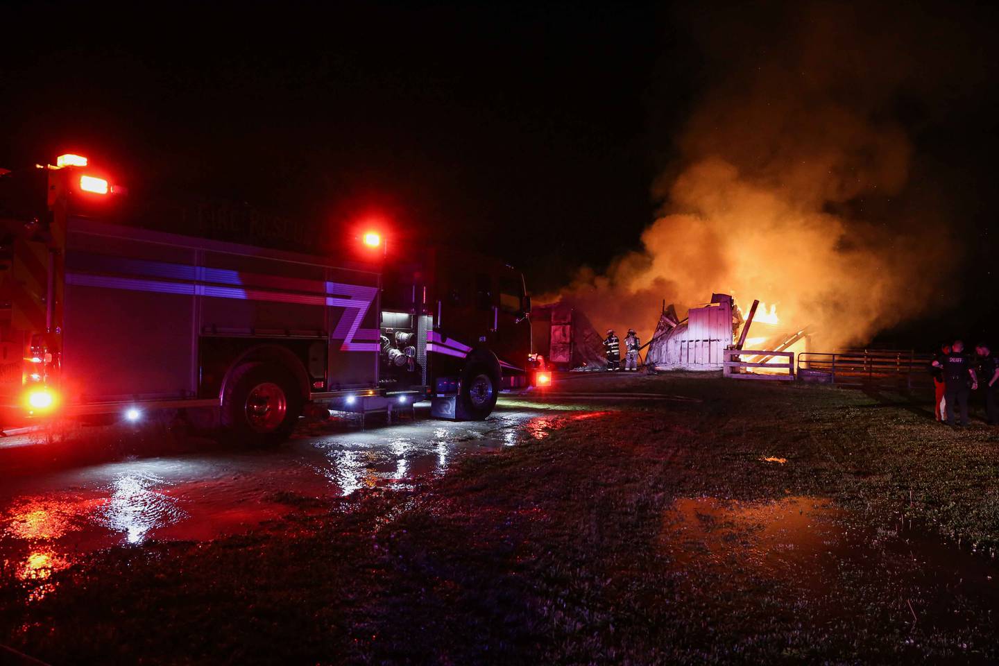Firefighters battle a blaze at a barn near Harvard on June 9, 2025, that killed six horses.