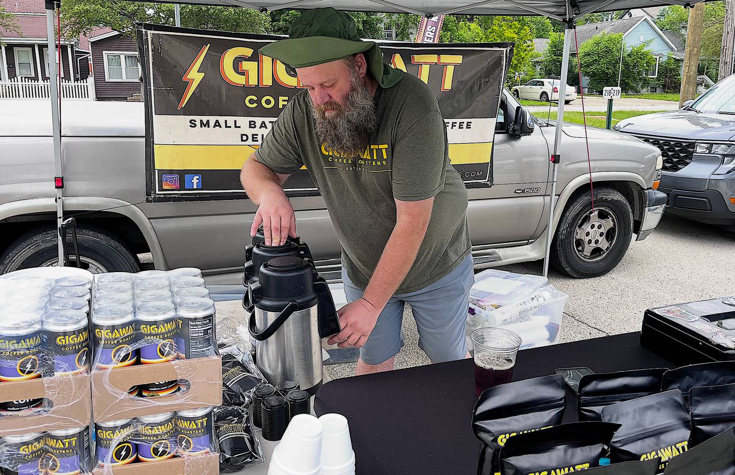 James Ravnic, lead roaster for Gigawatt Coffee Roasters, pours coffee for a customer on May 23, 2026 at Lockport Trackside Farmers Market.