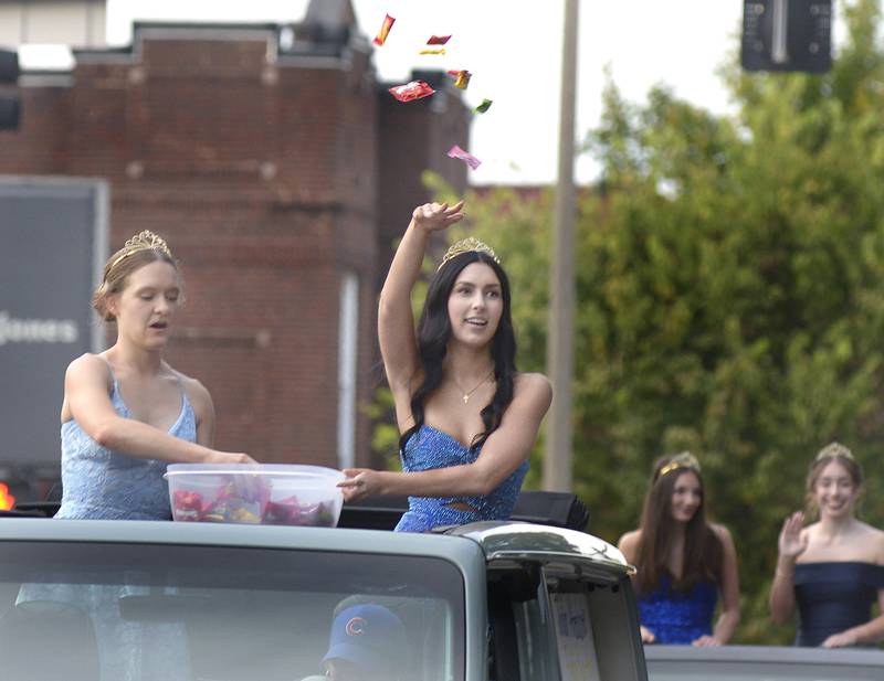 Members of the Marquette Academy High Homecoming Court toss treats to those along LaSalle St in Ottawa Wednesday for the school’s Homecoming parade.