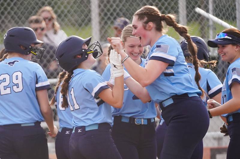 Downers Grove South's Addison Yurchak (11) is greeted at home by Ella Cushing (right) after hitting a two run homer against St. Charles East during a softball game at St. Charles East High School on Wednesday, April 10, 2024.