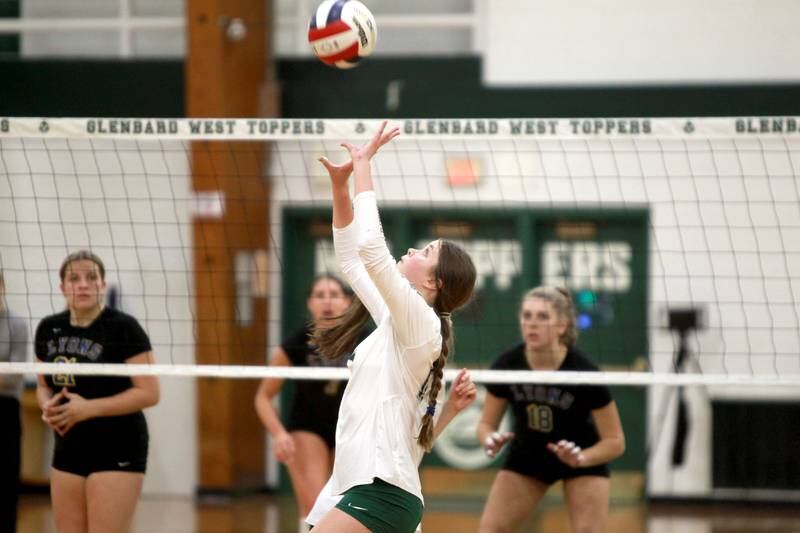 Glenbard West’s Cara Herbert sets the ball during a home game against Lyons Township in Glen Ellyn on Tuesday, Oct. 10, 2023.