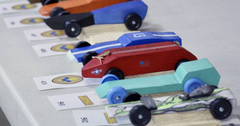 The row of pinewood derby cars includes  the red one belonging to Ayden Arnold, which is inscribed with a dedication: "Thank You St. Jude."