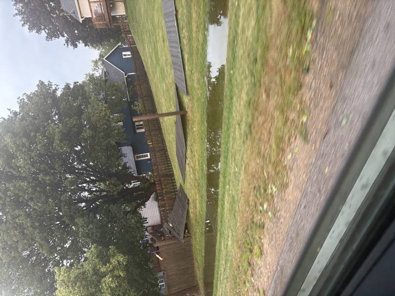 A fence is damaged and water collects in Cary after a storm on Aug. 16, 2025.