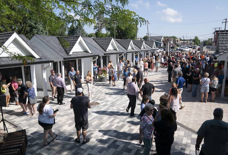 Shoppers explore the new collection of tiny shops at the grand opening and ribbon cutting of the new McHenry Riverwalk Shoppes in downtown McHenry on Friday, July 21, 2023.