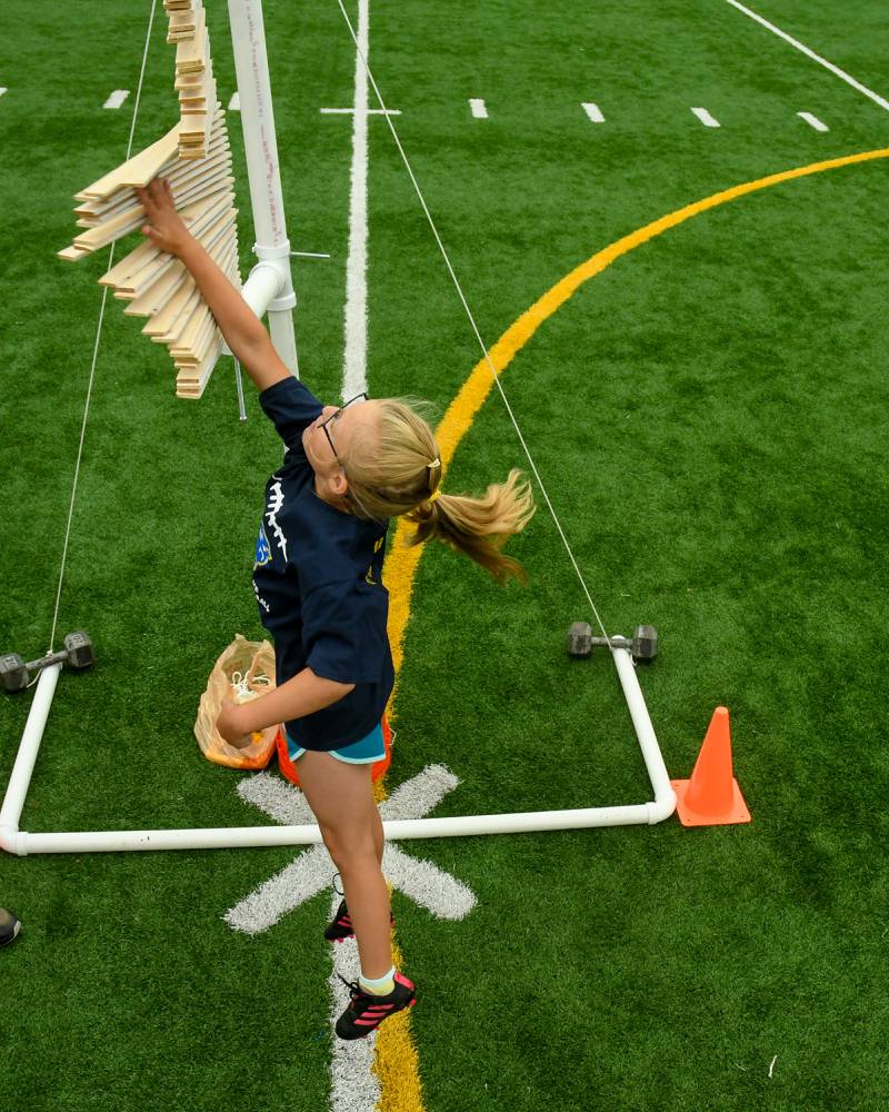 Elin Carlson, 7, of Downers Grove does a standing jump to see how high she can get during the NFL Youth Flag Football Combine Day held at Doerhoefer Park in Downers Grove on Sunday Aug. 6, 2023.