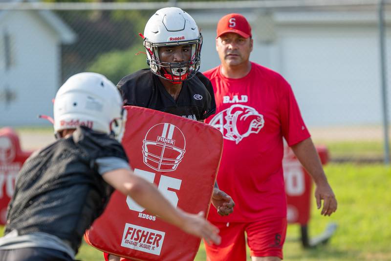 Sharon Morton of Streator holds pad as teammate charges him on Monday, August 11, 2025 at Streator High School in Streator.
