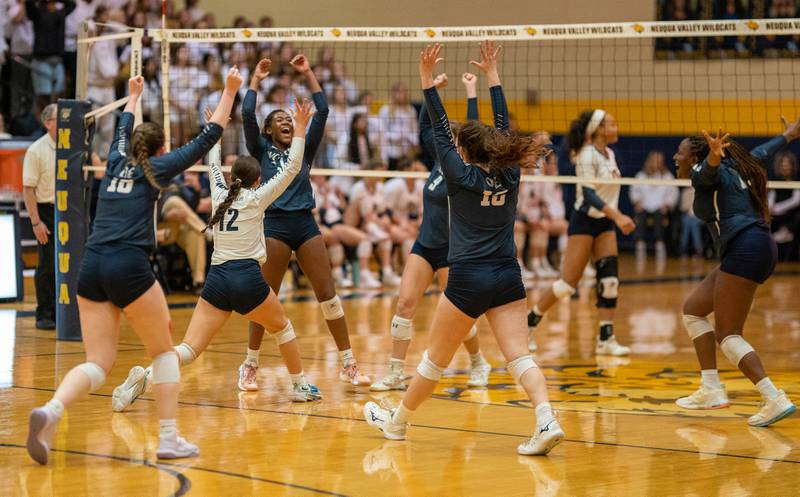 Oswego East players celebrate after winning the first set against Neuqua Valley during the Neuqua Valley 4A regional final volleyball match at Neuqua Valley High School in Naperville on Thursday, Oct 27, 2022.