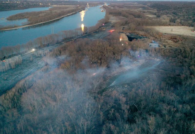 Smoke and charred timber burns from a large brush fire that broke out near the 12000 block of West Bottom Road on Monday, March 2, 2025 near Granville. The fire was elevated to the second alarm as the flames spread further west. Over 150 acres of timber burned along the Illinois River during the incident.