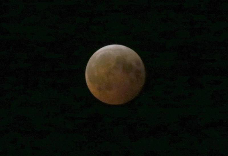 The moon gives off a red-orange glow during a total lunar eclipse on Friday, March 14, 2025 at City Hall Park in Princeton. A lunar eclipse occurs when the Sun, Earth, and Moon align so that the Moon passes into Earth’s shadow. When the Moon is within the umbra, it appears red-orange. Lunar eclipses are sometimes called “Blood Moons” because of this phenomenon. The next visible one in Illinois will not occur until March 3, 2026.