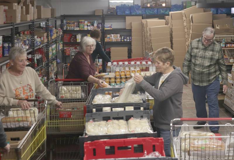 Volunteers gather perishable food during the Thanksgiving distribution on Wednesday, Nov. 19, 2025 at the Hall Township Food Pantry in Spring Valley. Nearly 500 families will receive food from this years distribution.