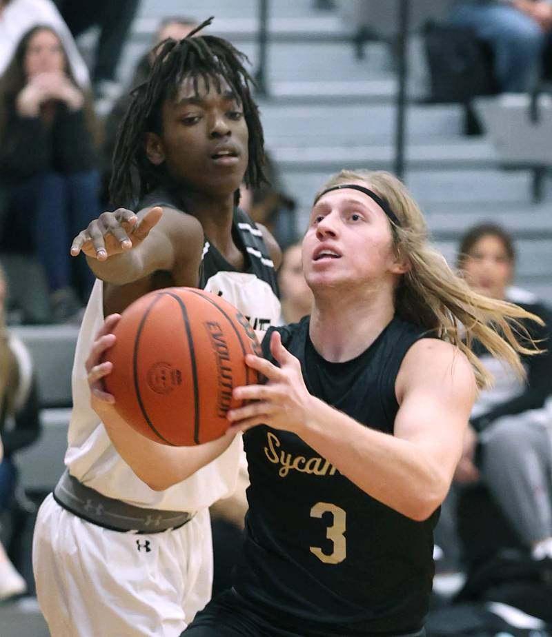 Kaneland's Freddy Hassan tries to block the shot of Sycamore's Carter McCormick during their game Friday, Jan. 5, 2024, at Kaneland High School in Maple Park.