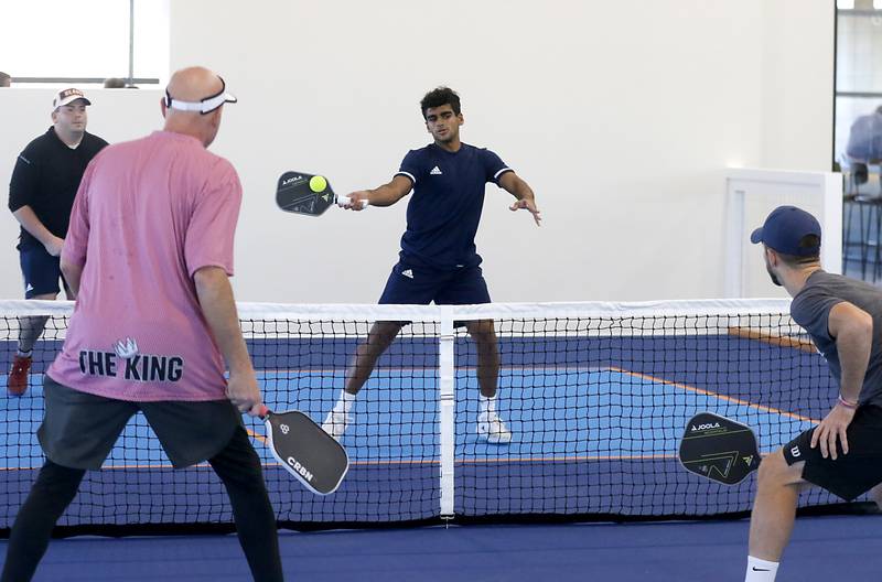 Ammar Wazir hits the ball while playing pickle ball uring a grand opening ceremony for the Pickle Haus in Algonquin, on Friday, Nov. 10, 2023. The Pickle Haus offers indoor pickle ball courts, food and drinks.