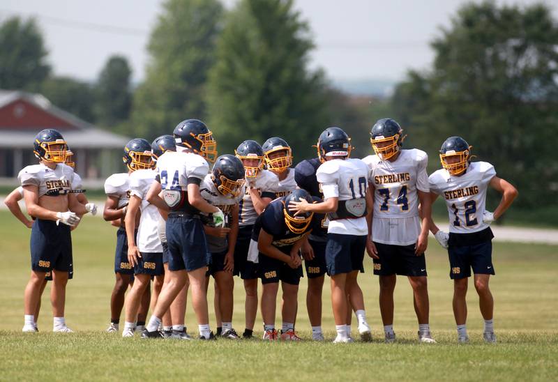 Sterling players huddle during a joint practice with Glenbard South and Oswego East football teams on Tuesday, July 15, 2025 in Oswego.