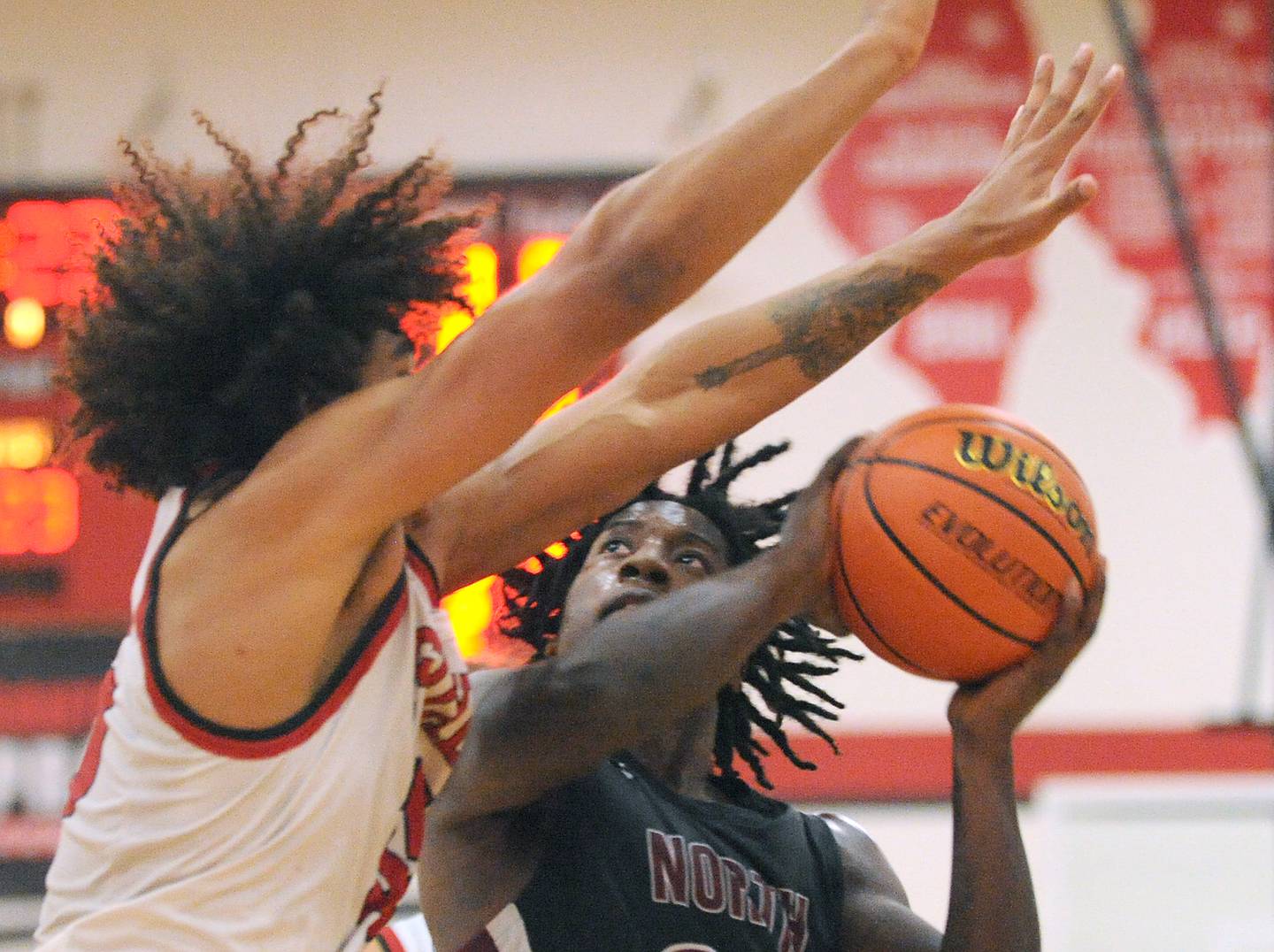 Plainfield North's Gerald Floyd eyes a shot against Yorkville defender LaBaron Lee (left) during a boys’ varsity game at Yorkville High School on Tuesday, Nov. 29, 2022.