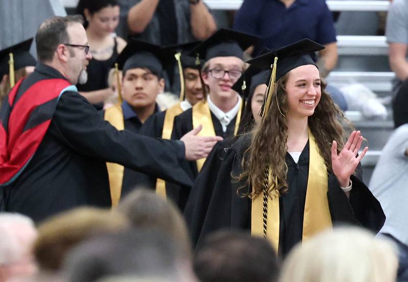 Graduation candidates wave to friends and family as they enter for commencement ceremonies Sunday, May 28, 2023, at Sycamore High School.